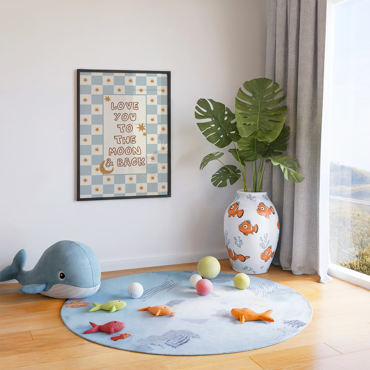 Love you to the moon nursery print in a black frame in a playroom with an ocean rug and whale plush