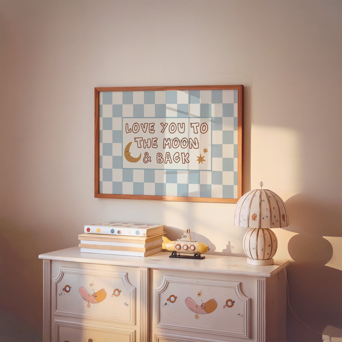 Landscape love you to the moon nursery print in a cherry wood frame above a painted dresser and lamp