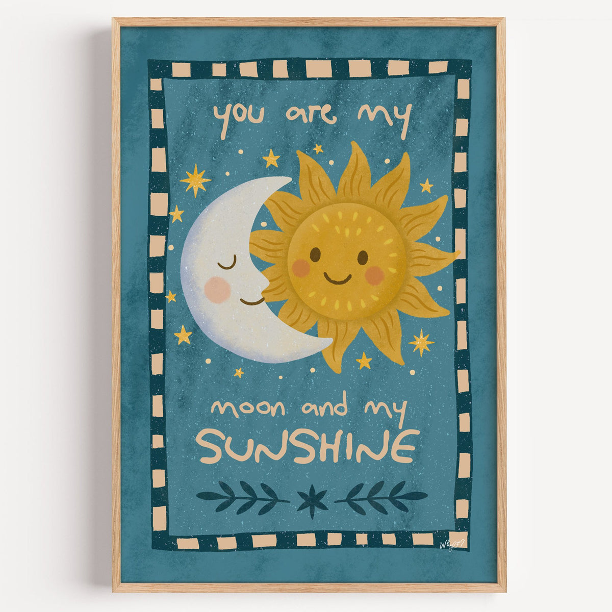 Sleepy moon and smiling sun nursery print in a light oak frame on a plain white wall