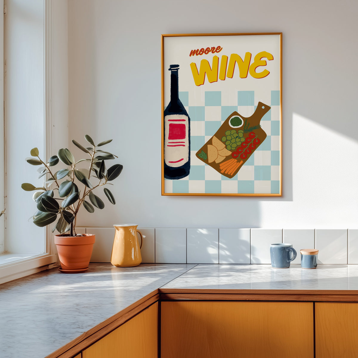 Wine and cheese board print shown in a gold frame above a marble counter with a yellow ceramic jug
