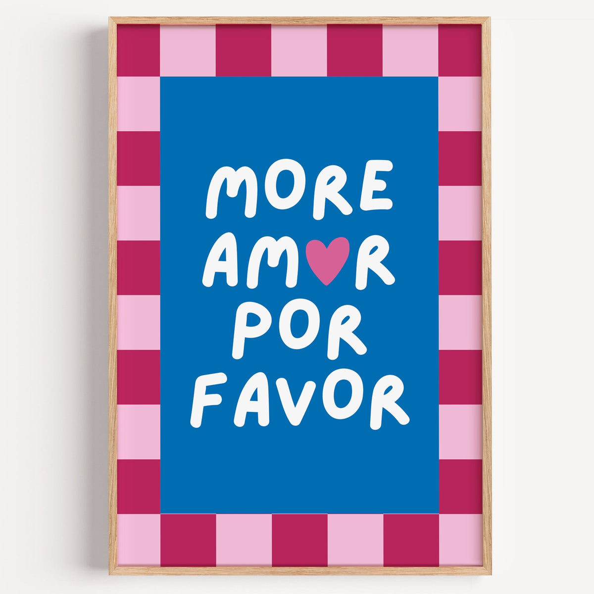 More Amor Por Favor print in a light oak frame on a plain white wall