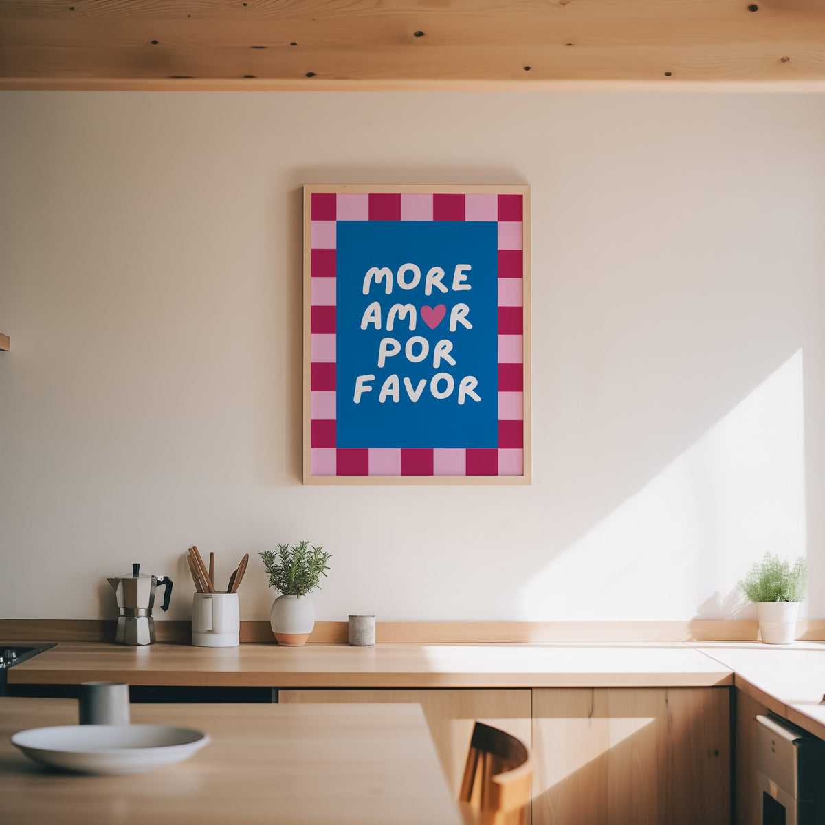 More Amor Por Favor print in an oak frame above a wood counter with a moka pot and herbs