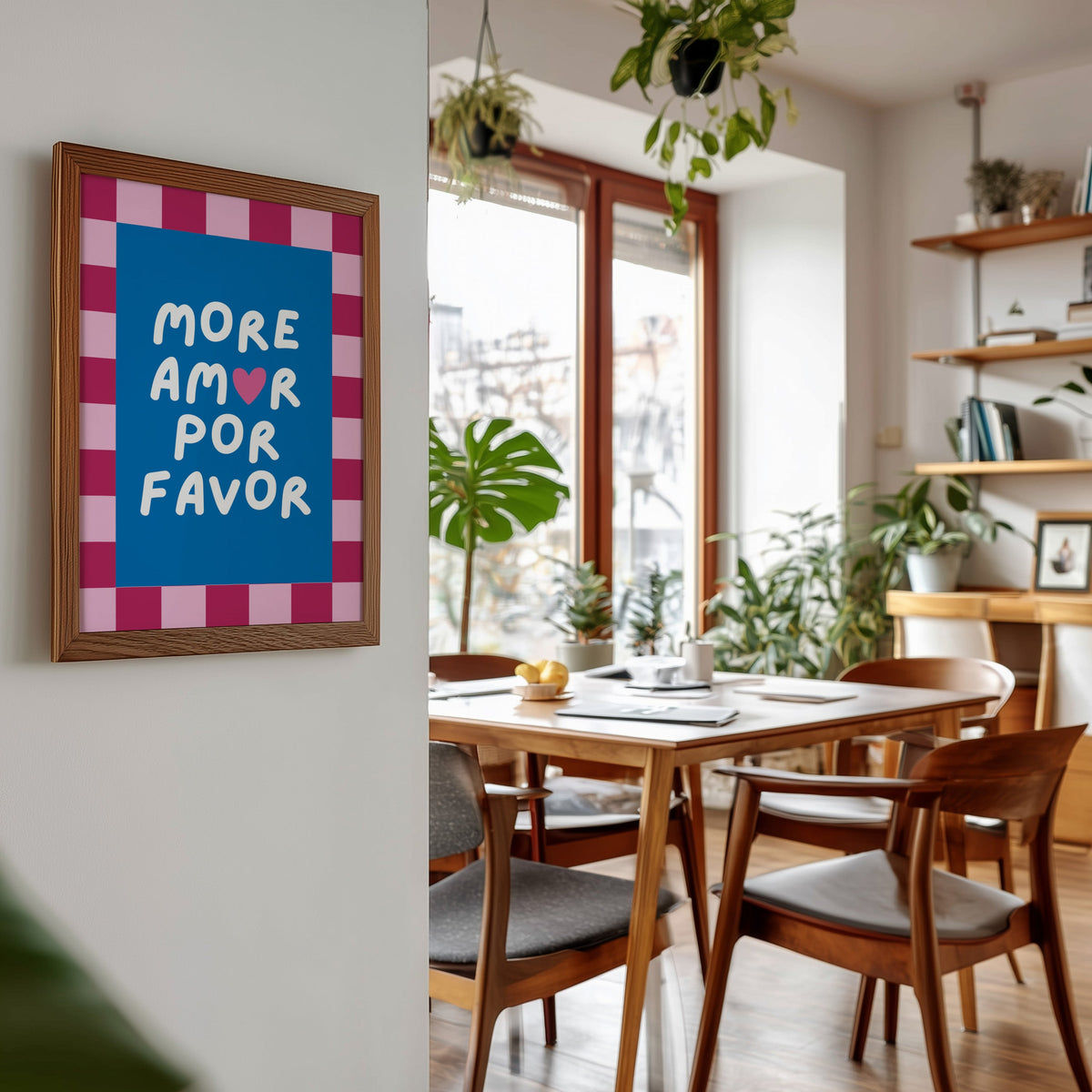 More Amor Por Favor print in a walnut frame beside a mid-century dining table