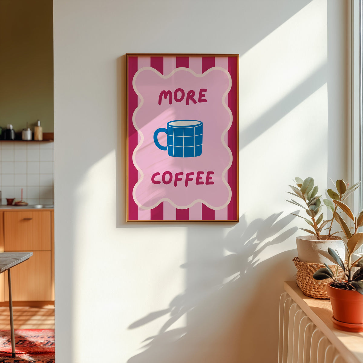 More Coffee mug print shown in a gold frame in sunlight with plants and a kitchen beyond