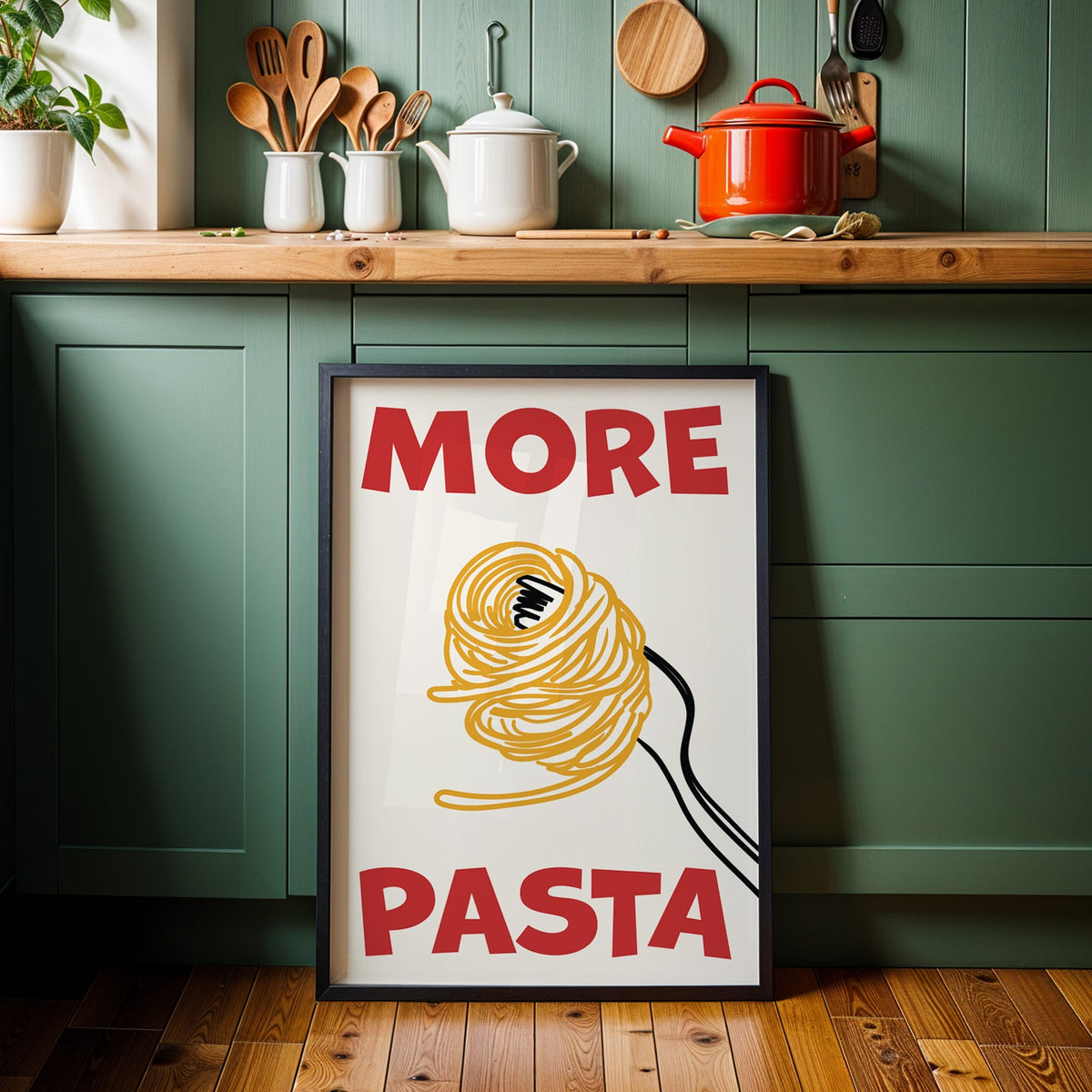 More pasta spaghetti print in a black frame against sage green kitchen cabinets