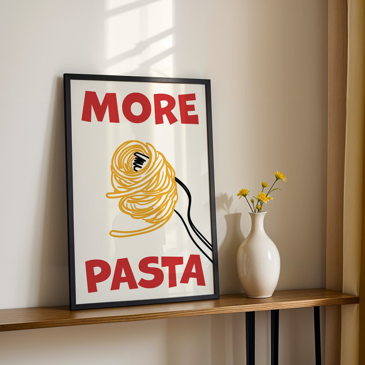 More pasta spaghetti print in a black frame on a console table with yellow daisies