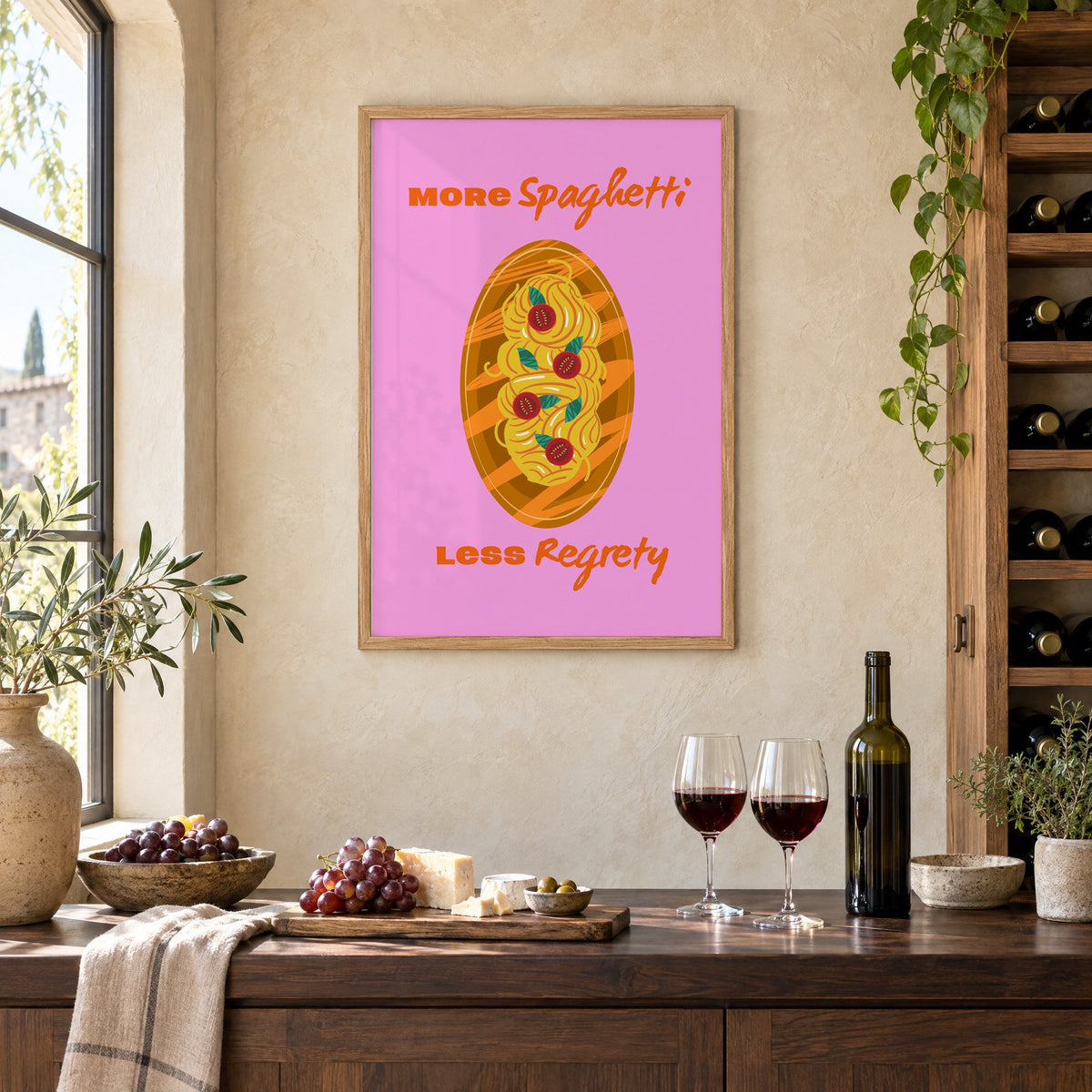 MORE Spaghetti LESS Regrety pasta plate print in an oak frame on a limewashed wall above a wine counter with red wine, cheese and grapes