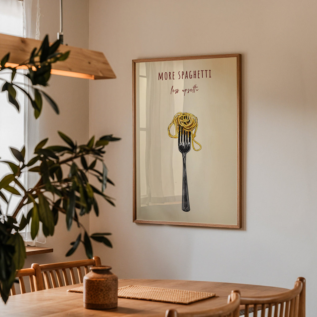 More Spaghetti Less Upsetti print in a walnut frame above a dining table with olive branches