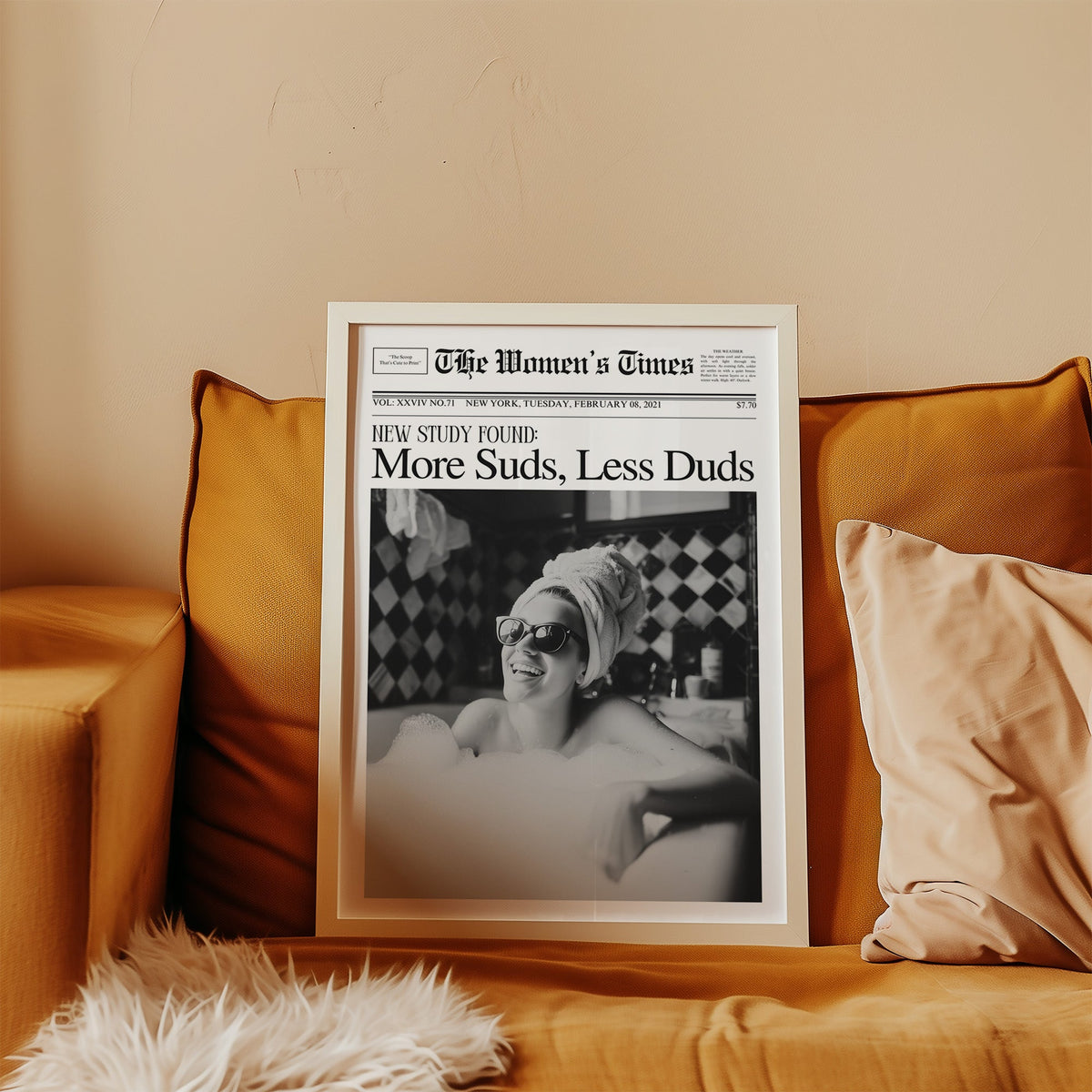 Woman in bubble bath mock newspaper print in a white frame leaning on a mustard velvet sofa