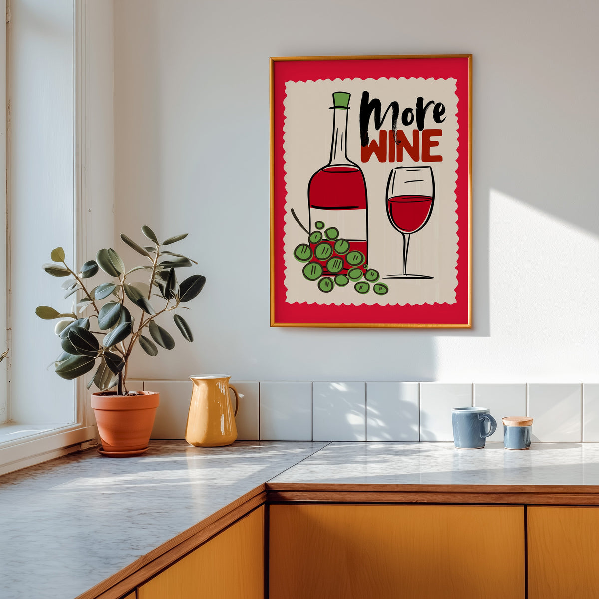 More Wine print in a gold frame above a marble counter with a yellow ceramic jug