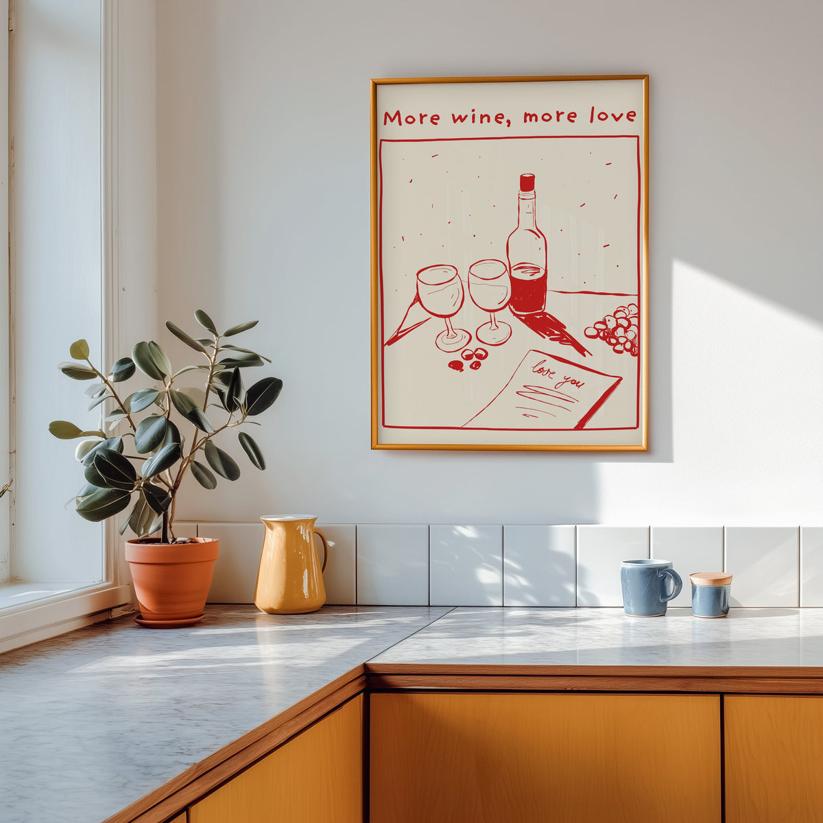 More Wine More Love print shown in a gold frame above a marble counter with a yellow ceramic jug