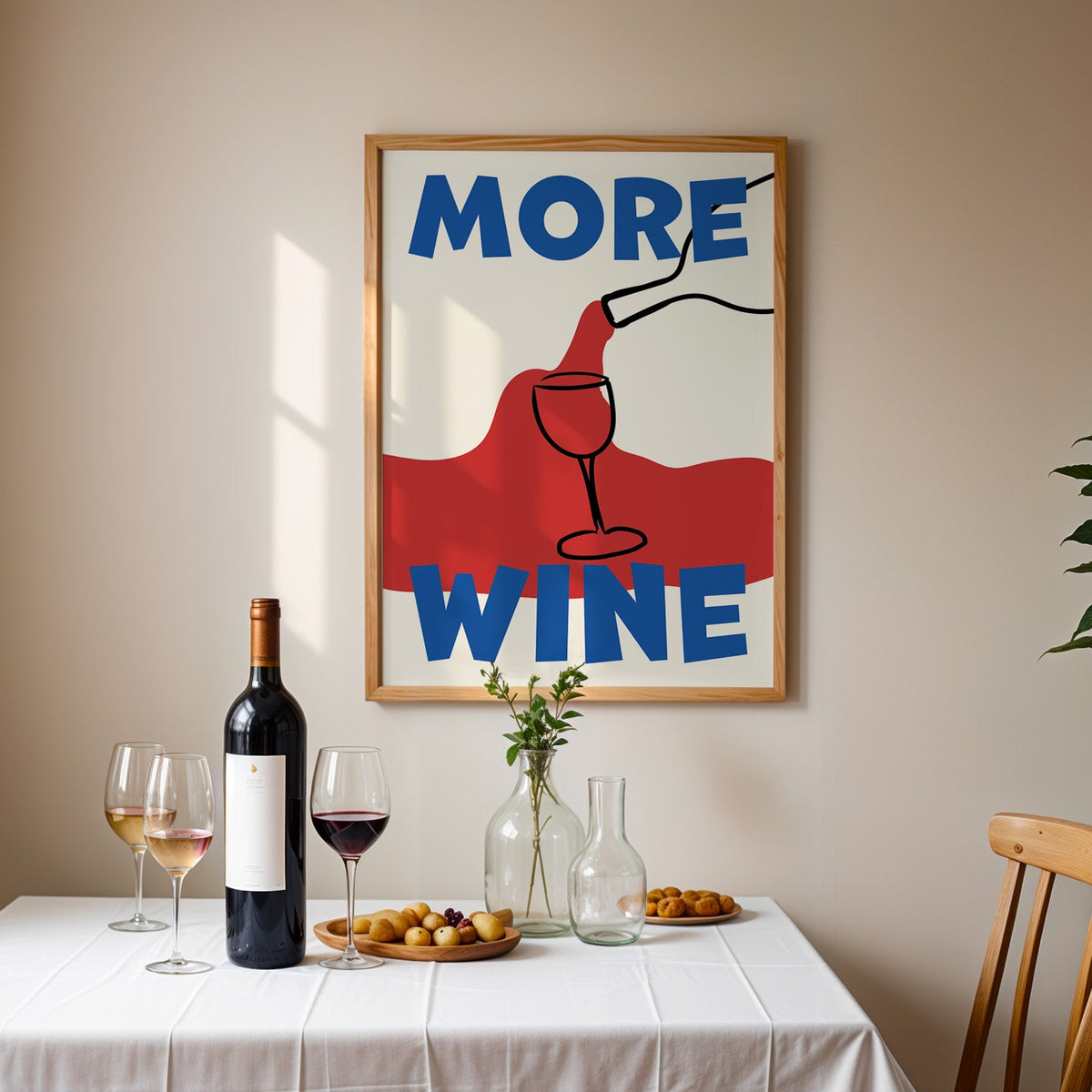 More wine red pour print in an oak frame above a table laid with red wine and glasses