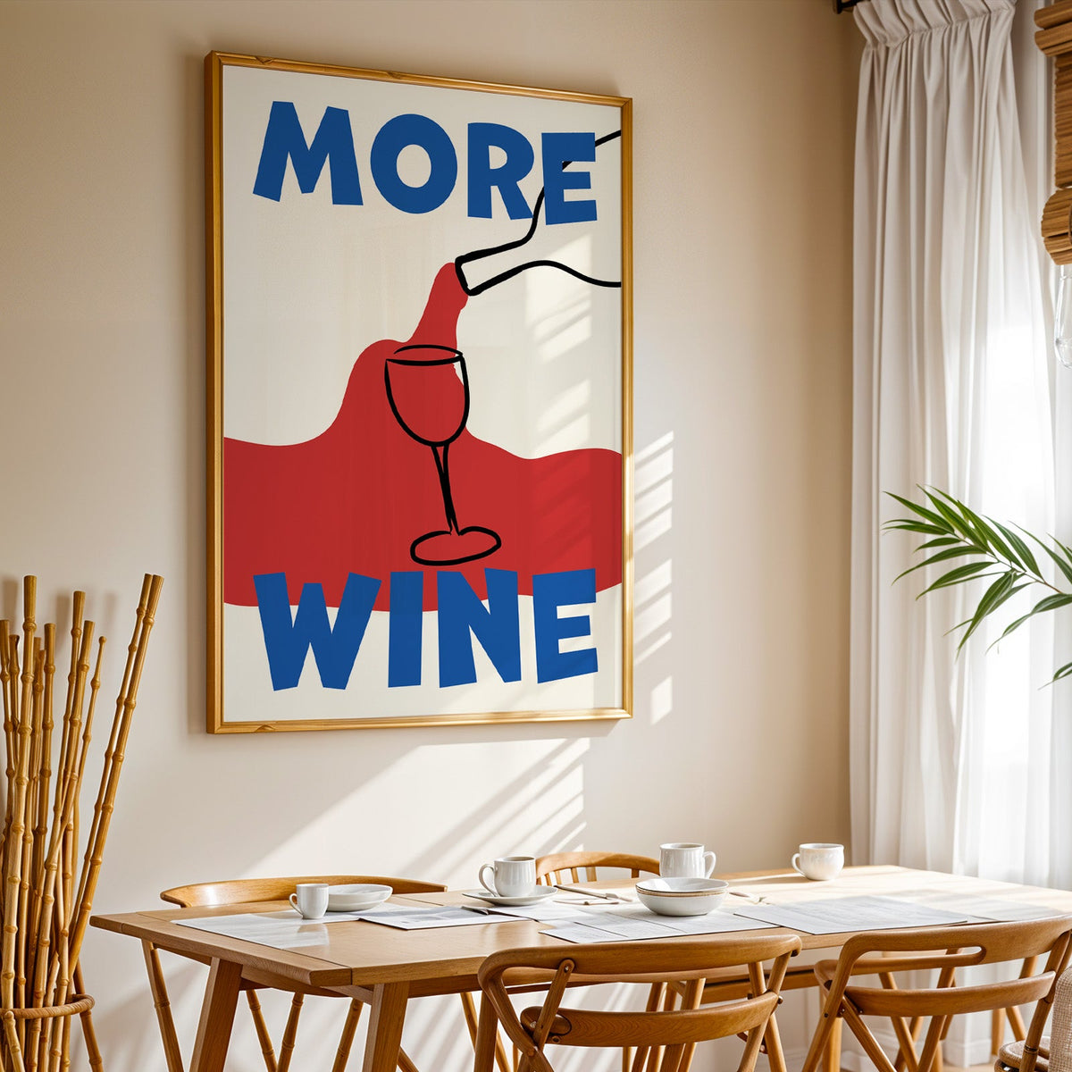 More wine red pour print in a gold frame above a sunlit breakfast table