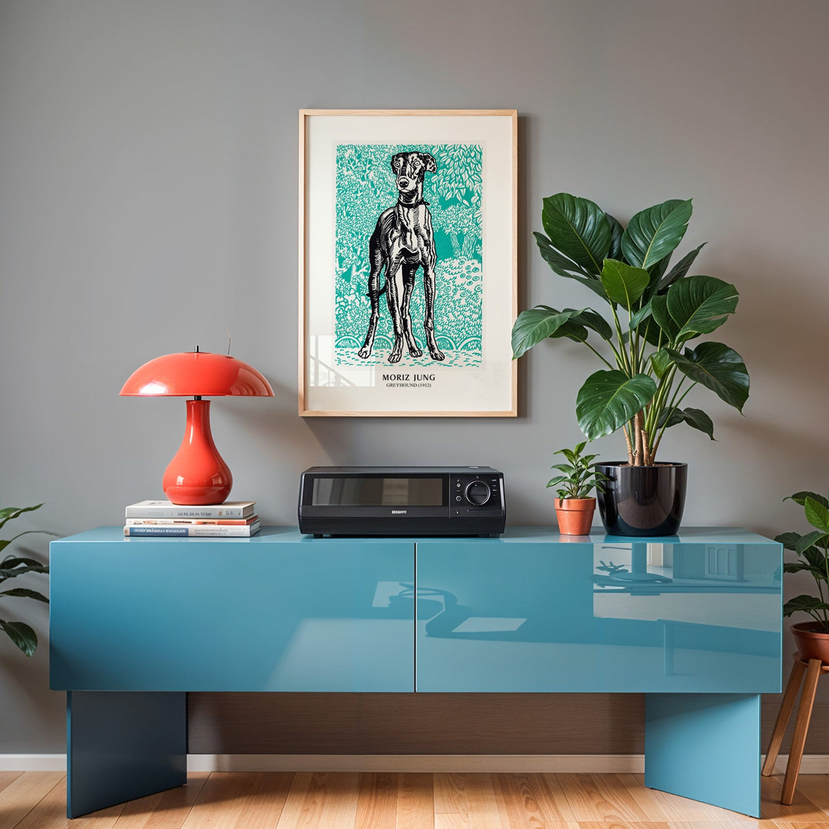Art nouveau dog print in an oak frame above a teal sideboard with a red lamp