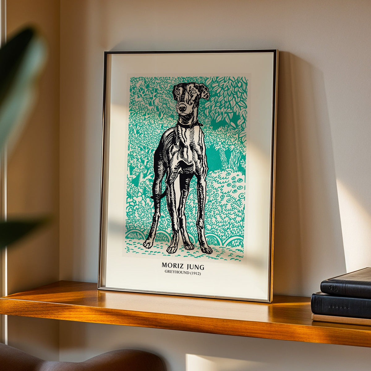 Greyhound print in a black frame on a walnut shelf in warm evening light