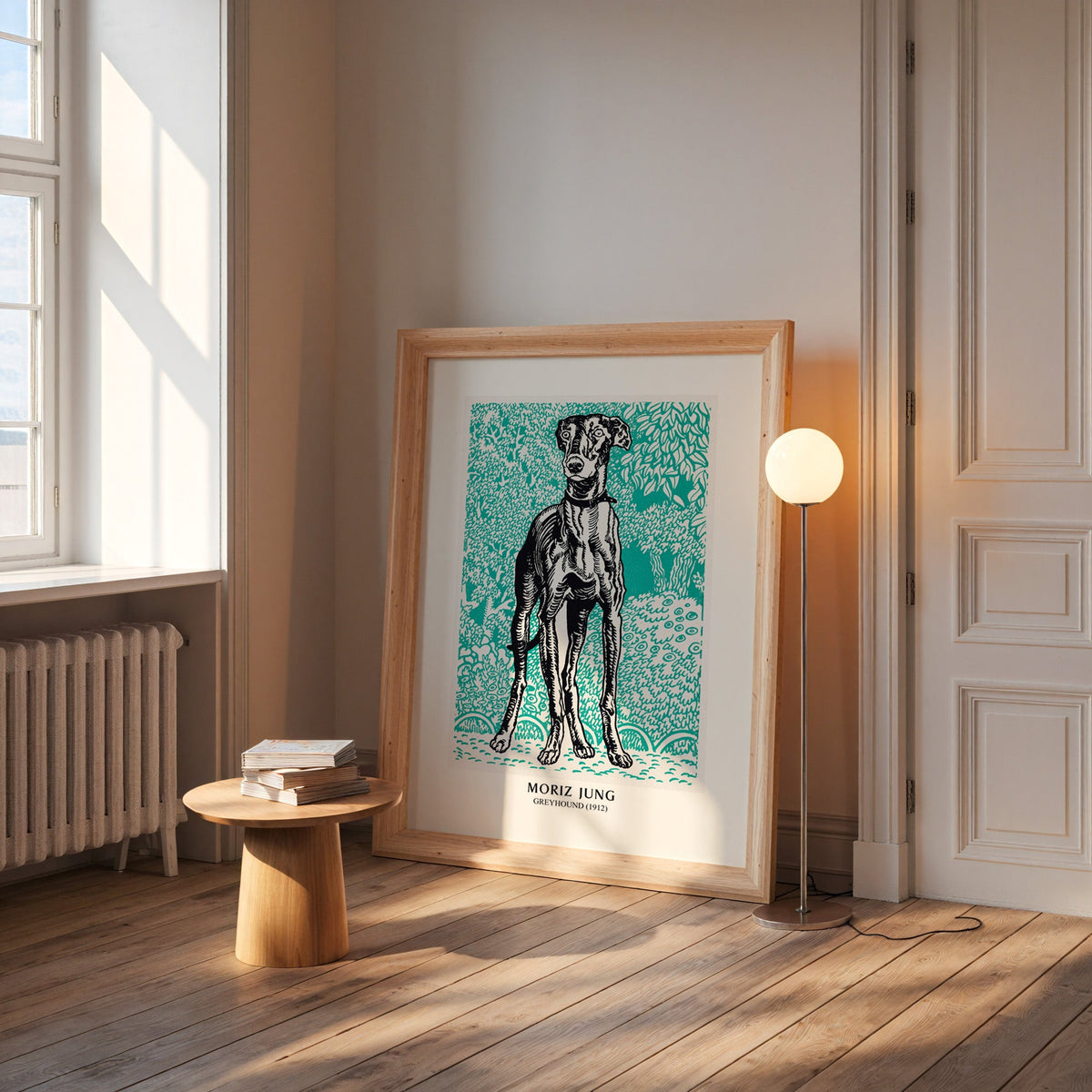 Moriz Jung poster in a wide pine frame leaning by a sunlit window