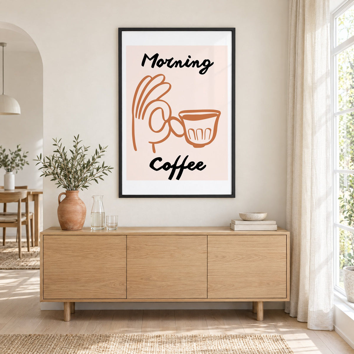 Morning Coffee terracotta hand cup print in a black frame above an oak sideboard with a terracotta vase of olive branches