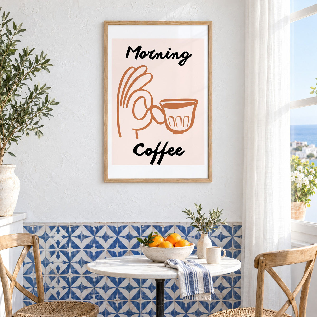 Morning Coffee terracotta hand cup print in an oak frame above a bistro table and blue patterned tiles
