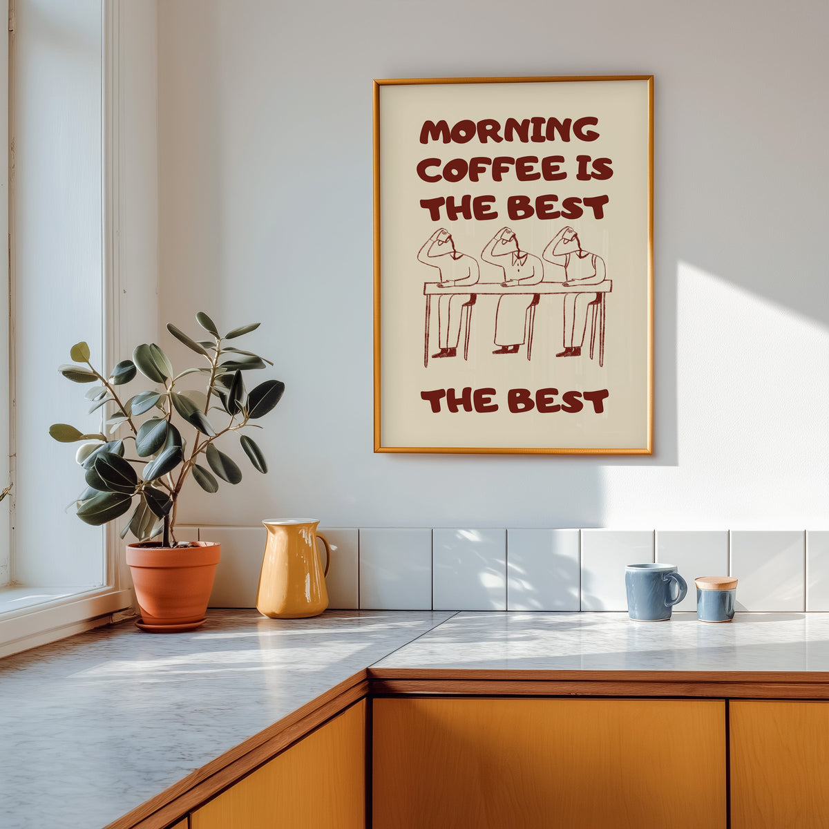 Morning Coffee Is The Best print shown in a gold frame above a marble counter in a tan kitchen