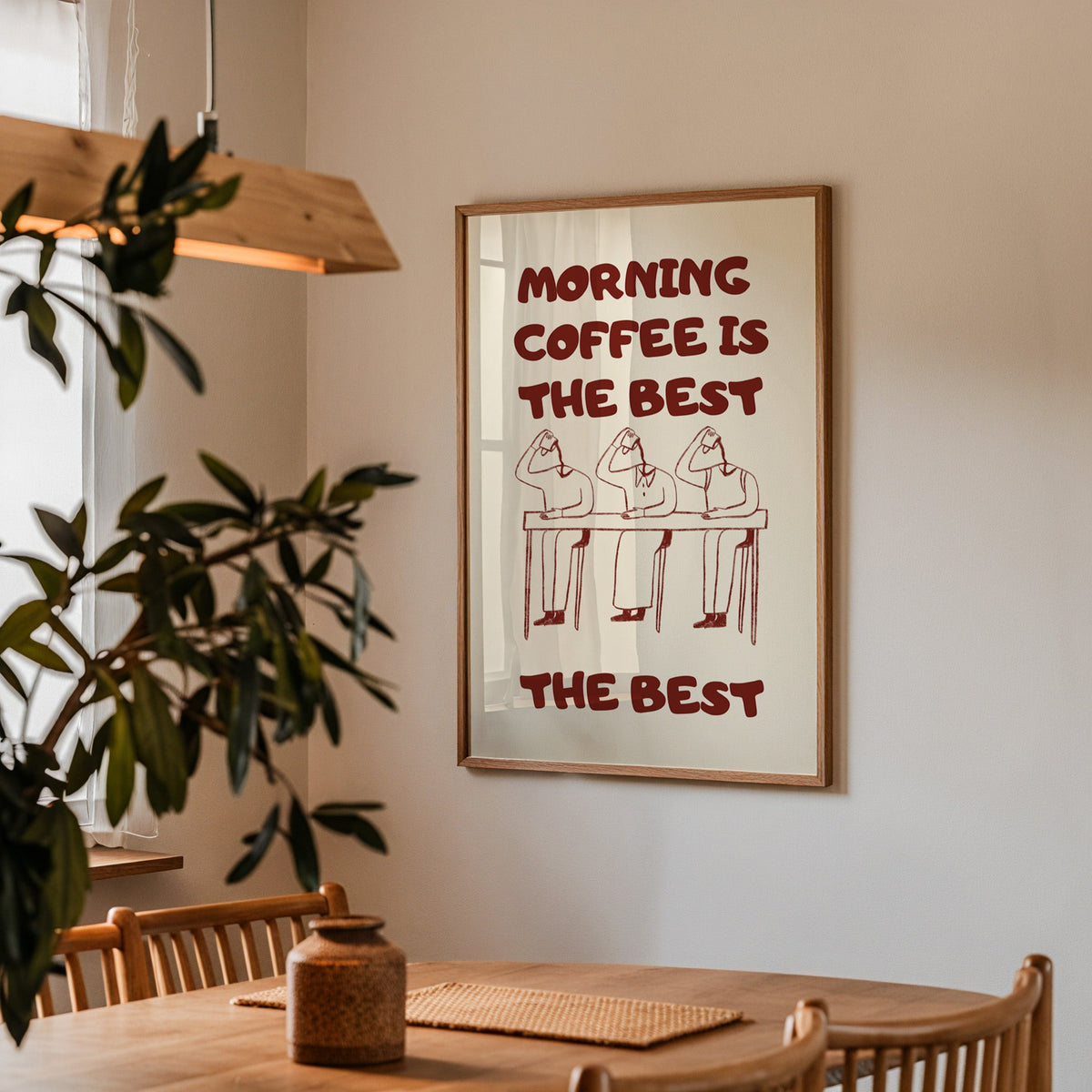 Morning Coffee Is The Best print in a walnut frame above a dining table with olive branches