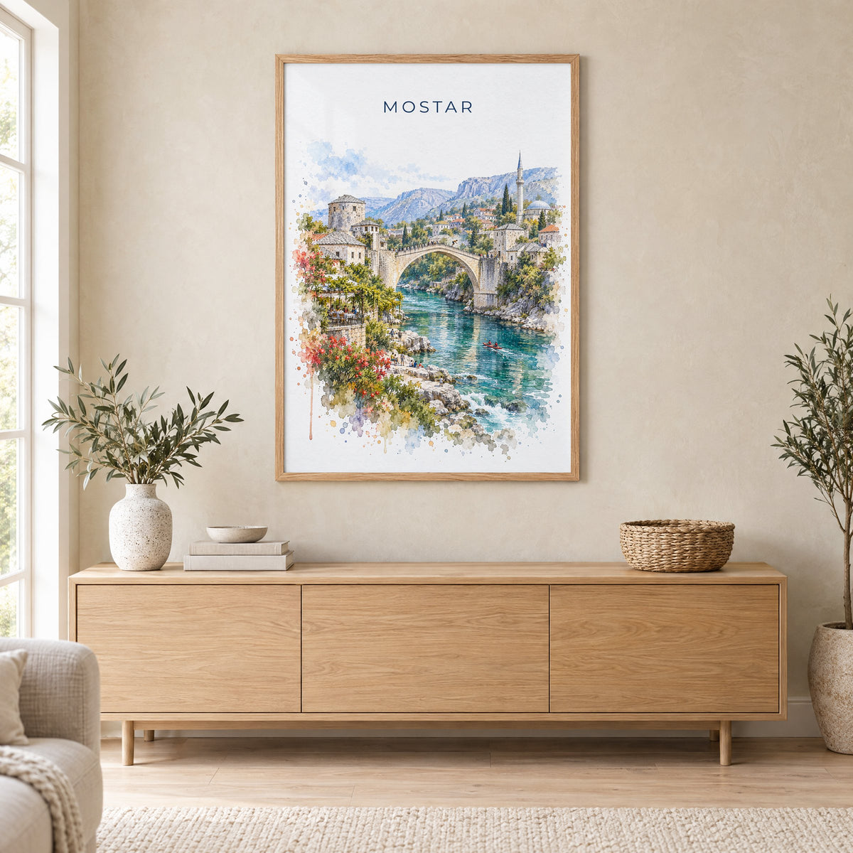 Mostar watercolor print in an oak frame above a light wood sideboard in a Scandinavian living room