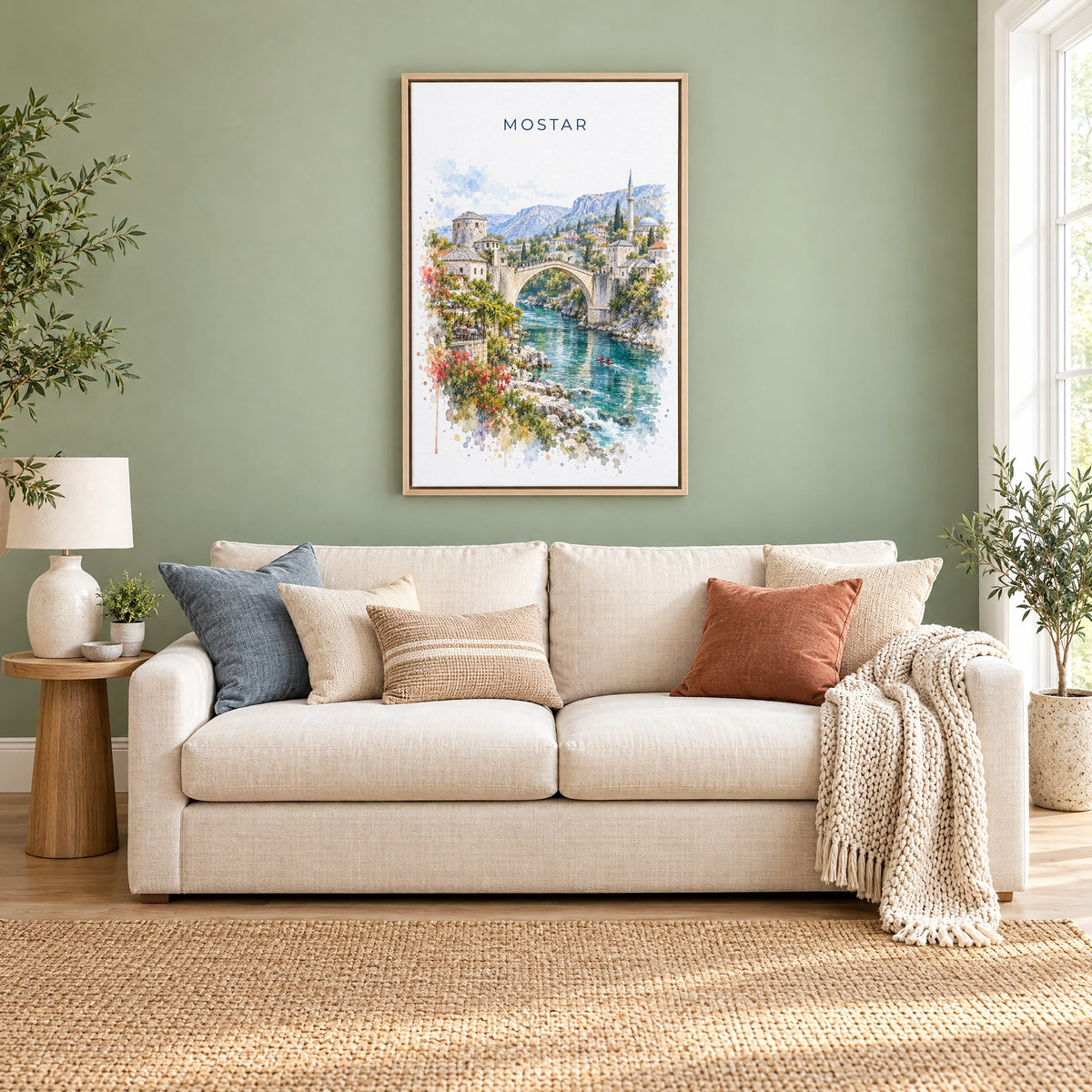 Mostar watercolor print as a natural floater canvas above a cream linen sofa on a sage green wall
