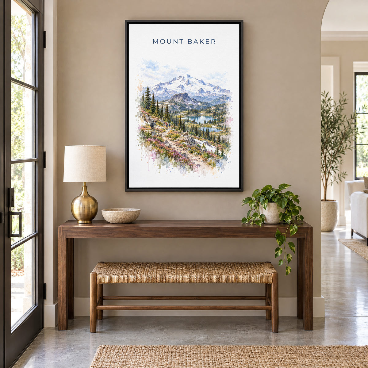 Mount Baker watercolor print as a black floater canvas above a walnut console and woven bench in an entryway