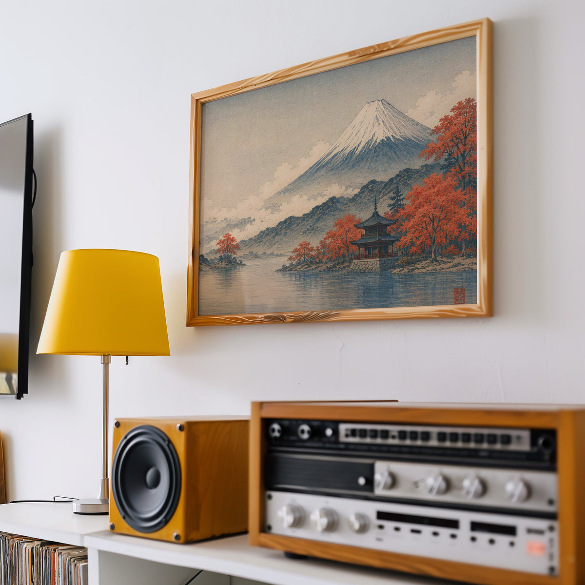 Mount Fuji autumn lake and pagoda print in a pine frame above a vintage stereo and a yellow table lamp