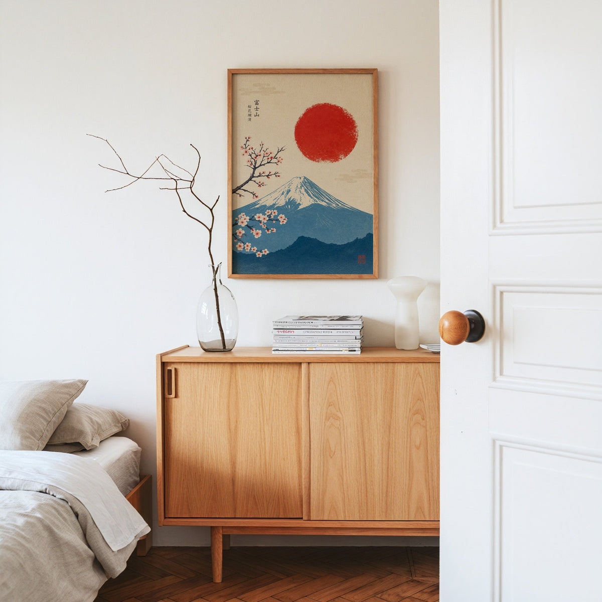 blue Mount Fuji with red sun and sakura print in an oak frame above an oak sideboard in a bedroom with linen bedding