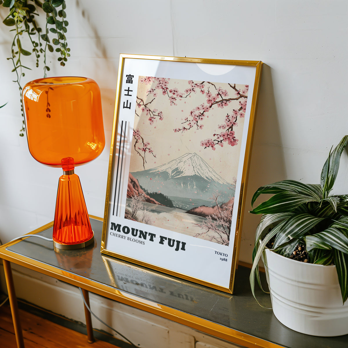 Mount Fuji cherry blooms lake print shown in a gold frame on a console beside an orange glass lamp
