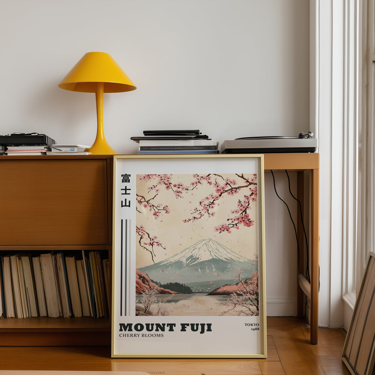 Mount Fuji cherry blooms lake print shown in a gold frame below a teak desk with a yellow lamp