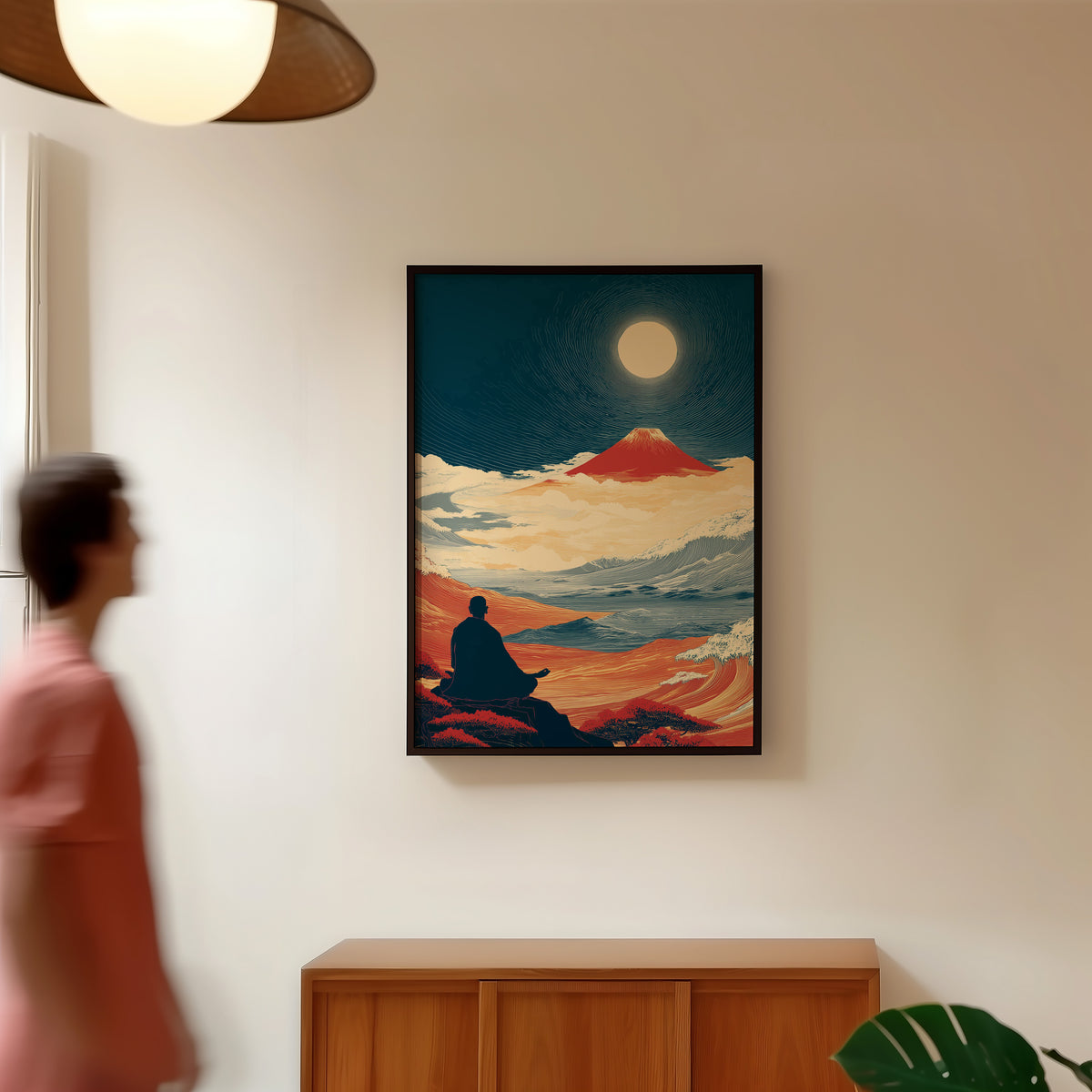 Meditating monk and red Fuji print in a black frame in a hallway under a rattan pendant
