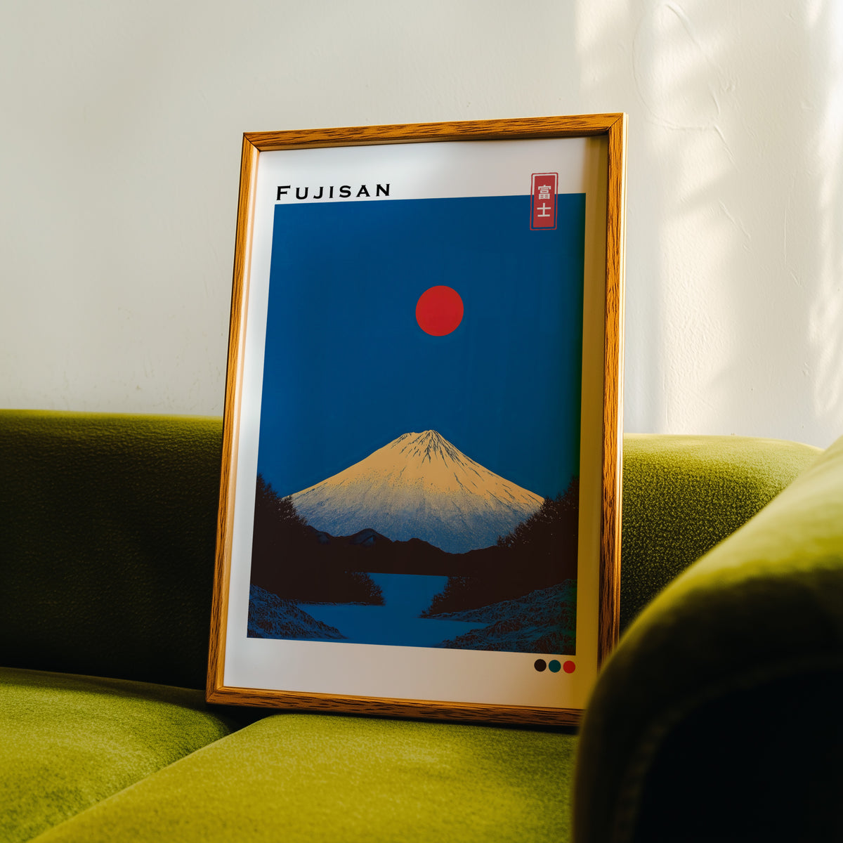 Minimal golden Mount Fuji print in an oak frame propped on a green velvet sofa