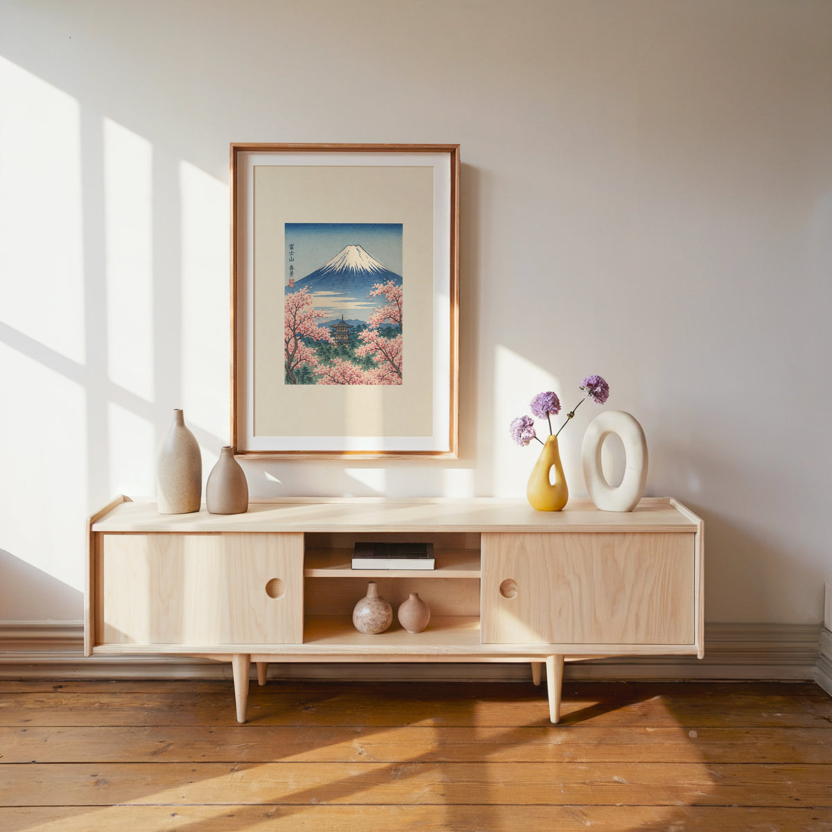 Mount Fuji with pagoda in spring print shown in a wood frame with a white mat above a pale wood media console