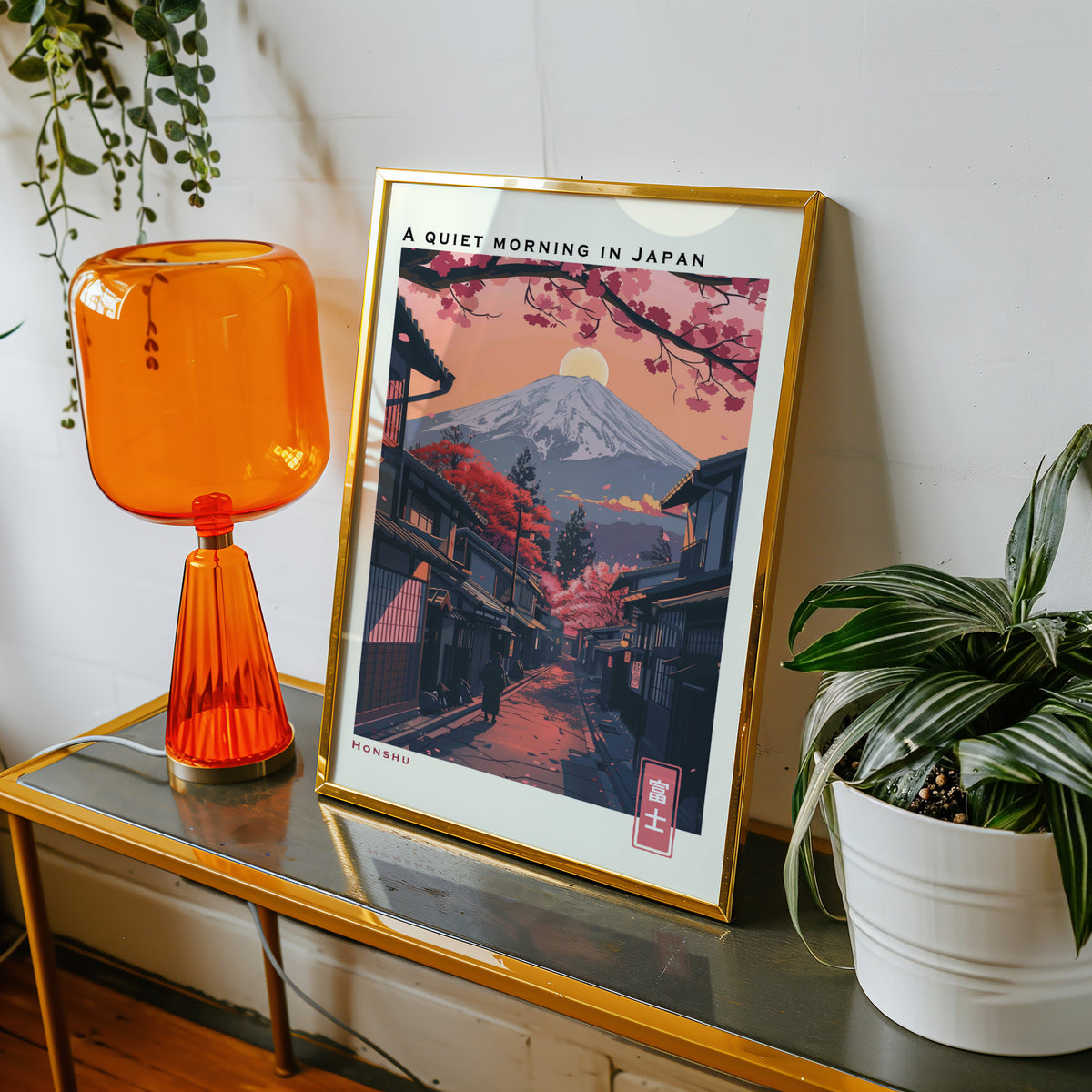 Quiet morning Fuji street print shown in a gold frame on a console beside an orange glass lamp