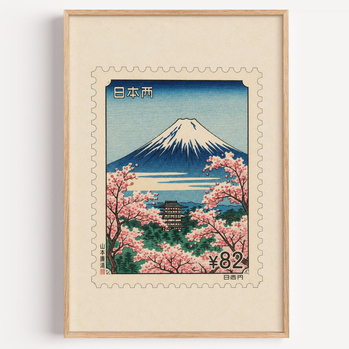 Mount Fuji sakura postage stamp print in a light oak frame on a plain white wall