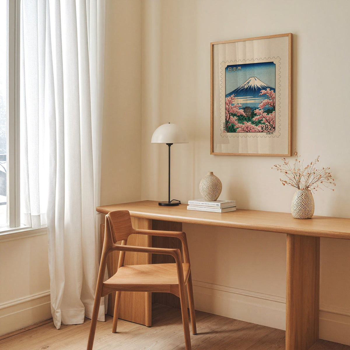 Mount Fuji sakura postage stamp print in an oak frame above a long oak desk with a white dome lamp and woven vases