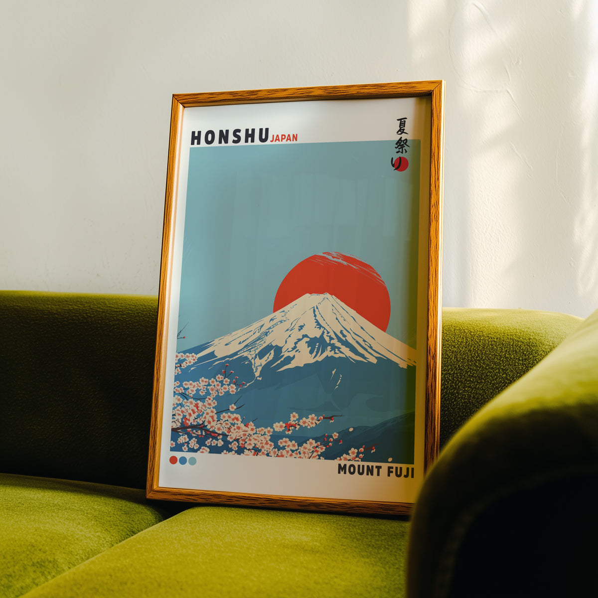 Mount Fuji red sun sakura print in an oak frame propped on a green velvet sofa