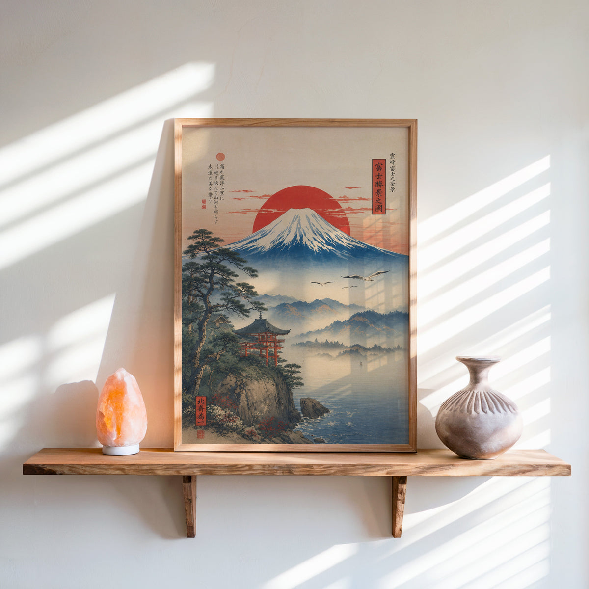 Mount Fuji sunrise with cliff shrine print in an oak frame on a live-edge wall shelf with a salt lamp and clay vase