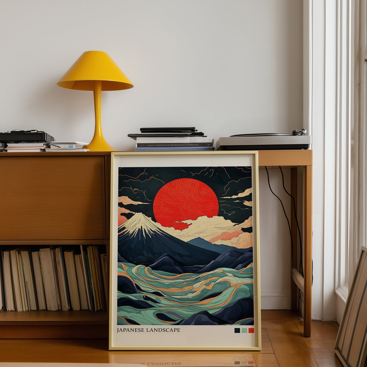 Fuji teal waves red sun print shown in a gold frame below a teak desk with a yellow lamp