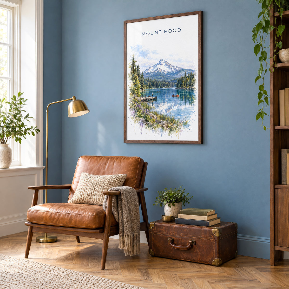 Mount Hood watercolor print in a walnut frame on a blue wall above a leather armchair in a reading nook