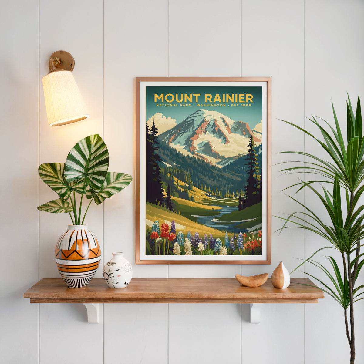 Mount Rainier National Park print in a copper frame above an oak shelf on white shiplap with a brass sconce