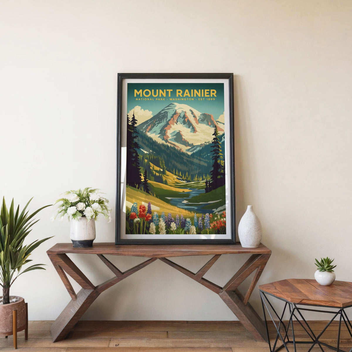 Mount Rainier poster in a black frame on an entryway console table beside white flowers and a yucca