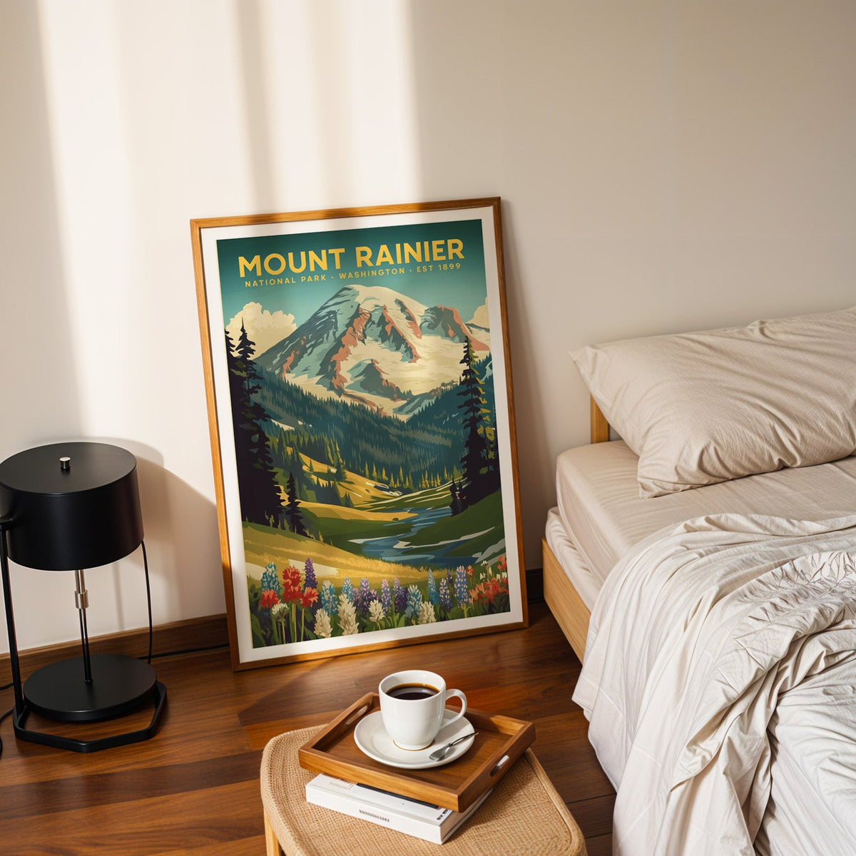 Mount Rainier National Park print in an oak frame leaning on a bedroom floor beside the bed and a coffee tray
