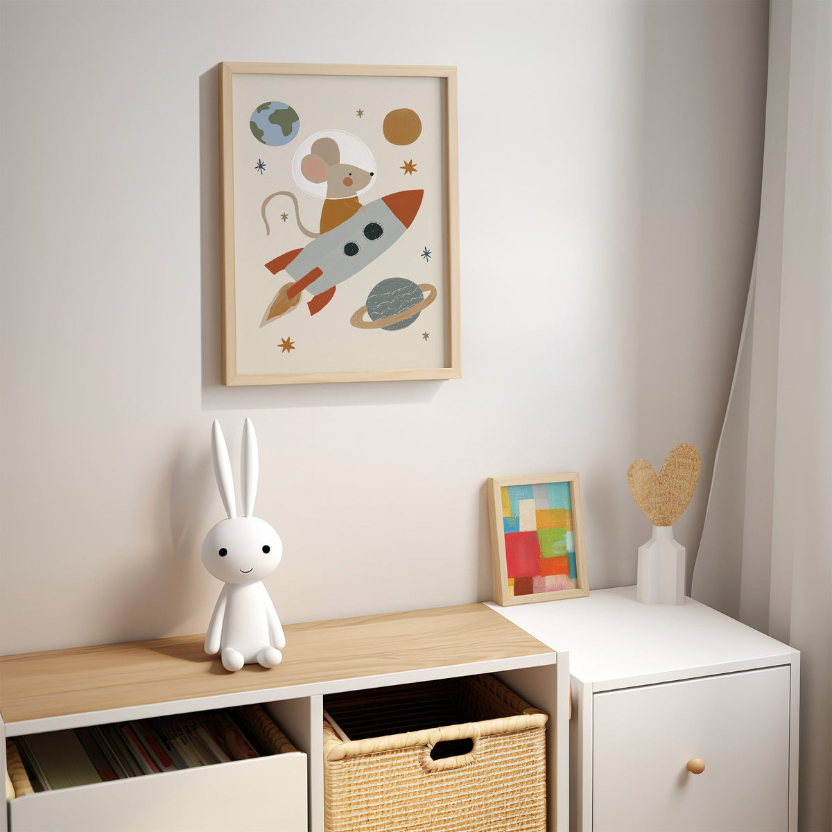 Mouse astronaut riding rocket nursery print in an oak frame above a kids cubby shelf with a woven basket and bunny lamp