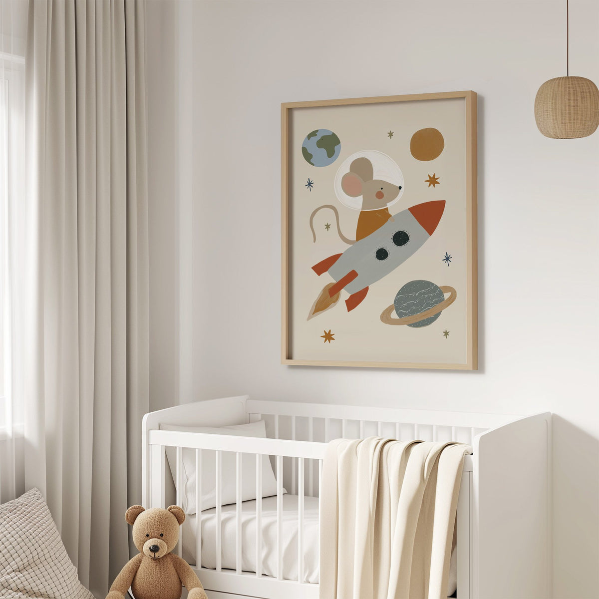 Mouse astronaut riding rocket nursery print in an oak frame above a white crib with a teddy bear