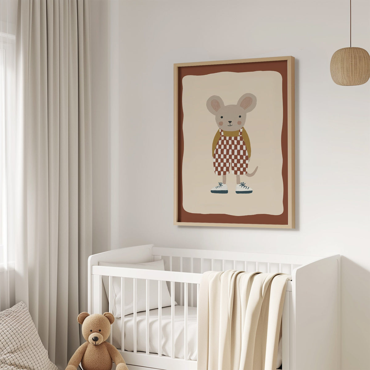 Mouse checkered overalls nursery print in an oak frame above a white crib with a teddy bear