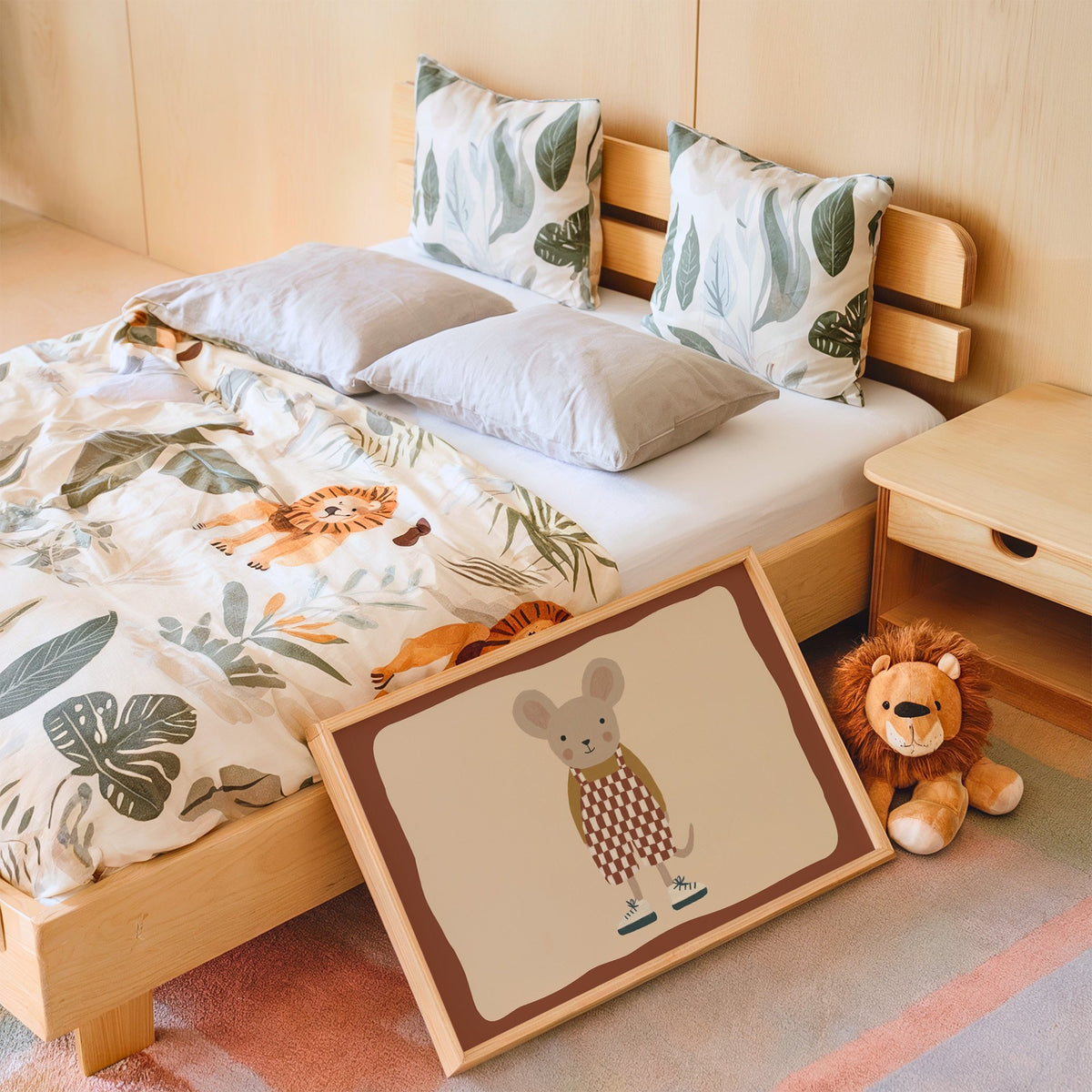 Landscape mouse checkered overalls nursery print in an oak frame leaning on a kids bed by a lion plush