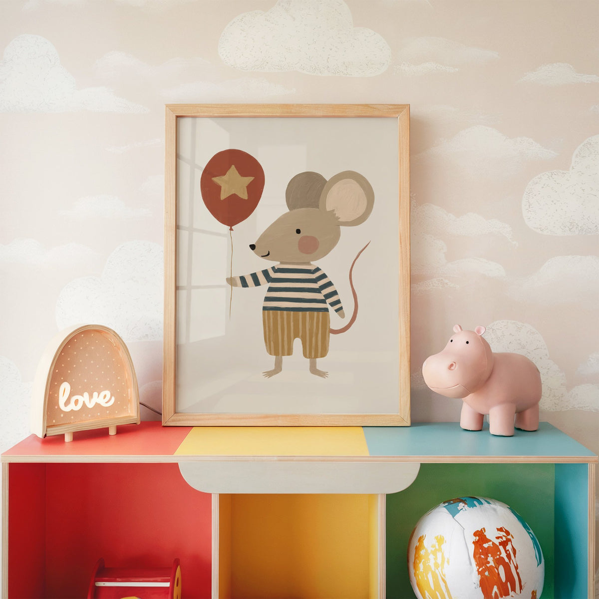 Mouse star balloon striped shirt nursery print in an oak frame on a rainbow toy shelf against cloud wallpaper