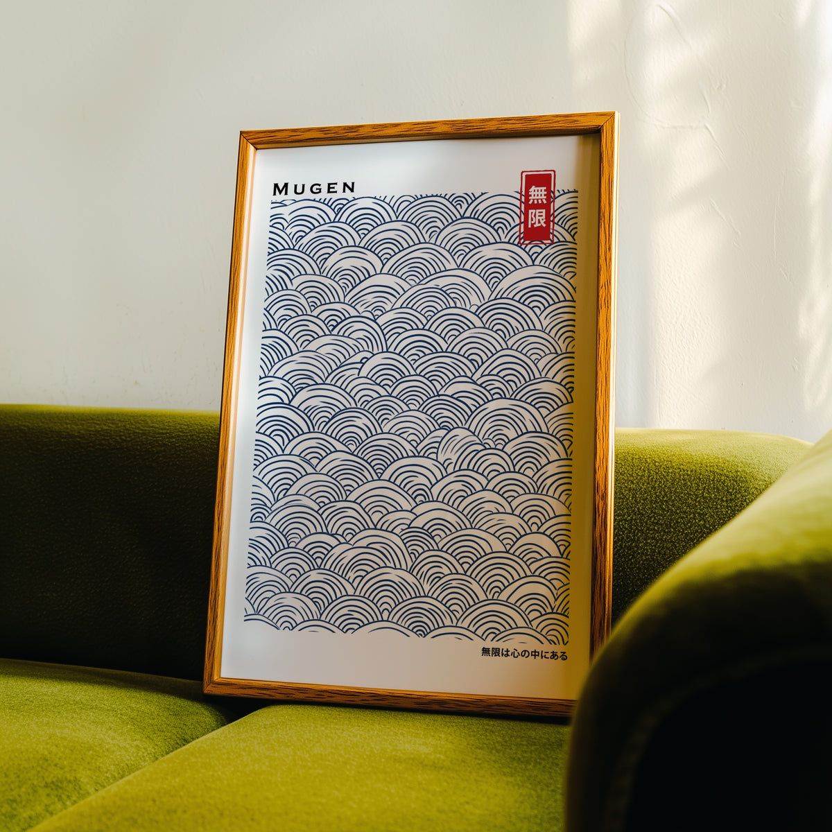 Navy seigaiha wave pattern print in an oak frame propped on a green velvet sofa